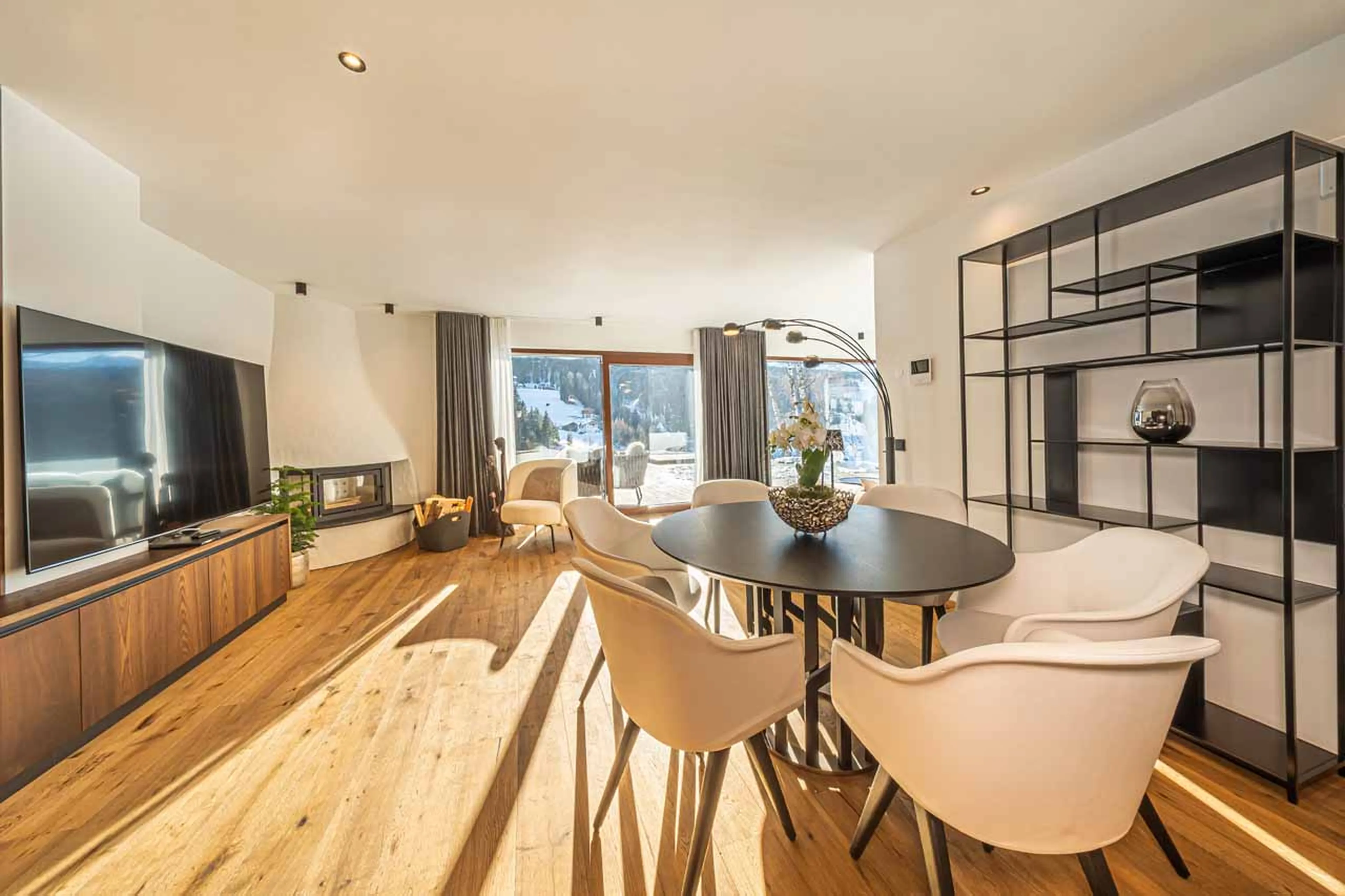 Fireplace, tv and table in living room at Chalet Carolina in Val Gardena