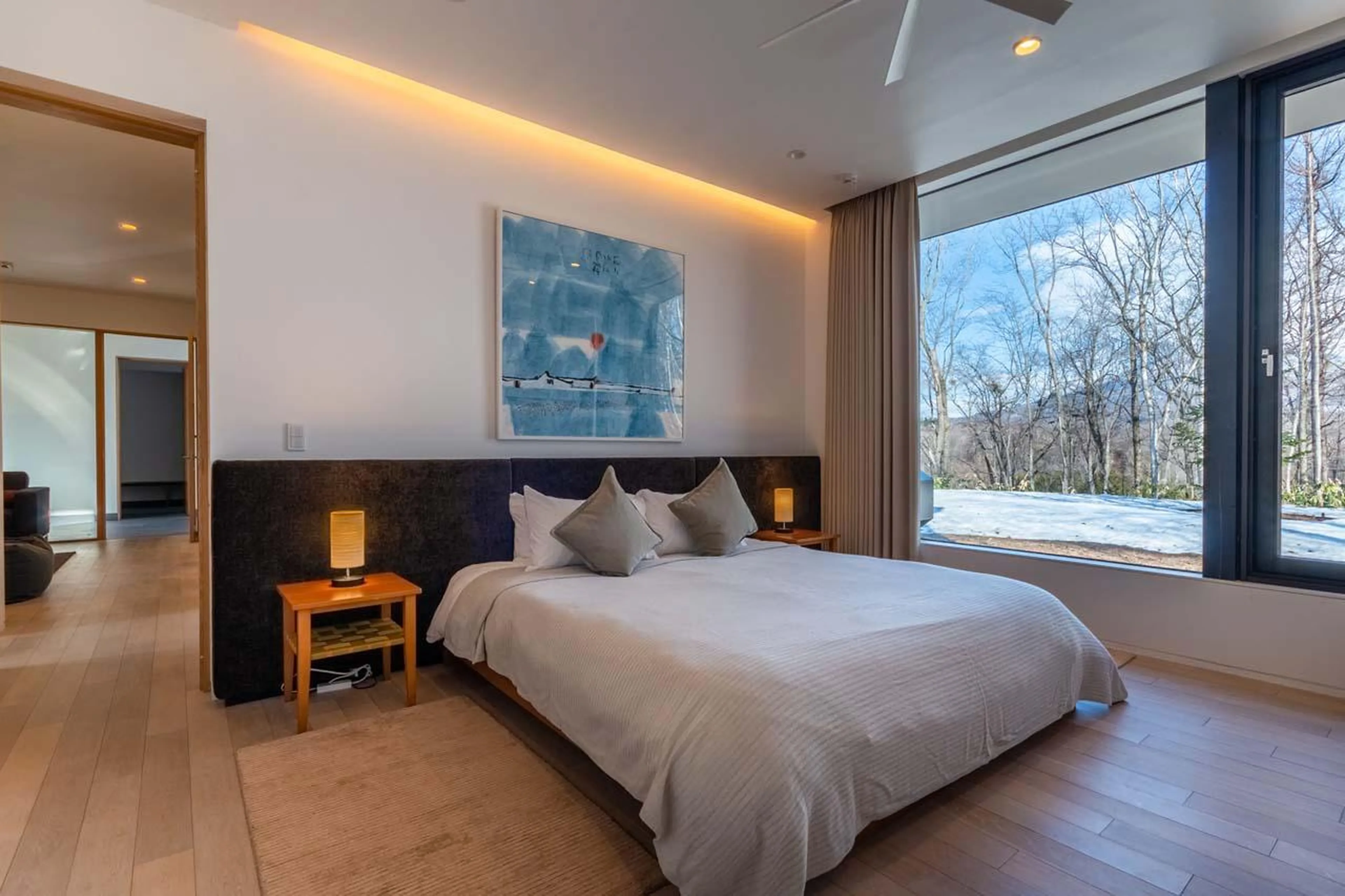 Bright bedroom with expansive windows at Yanagi House in Niseko