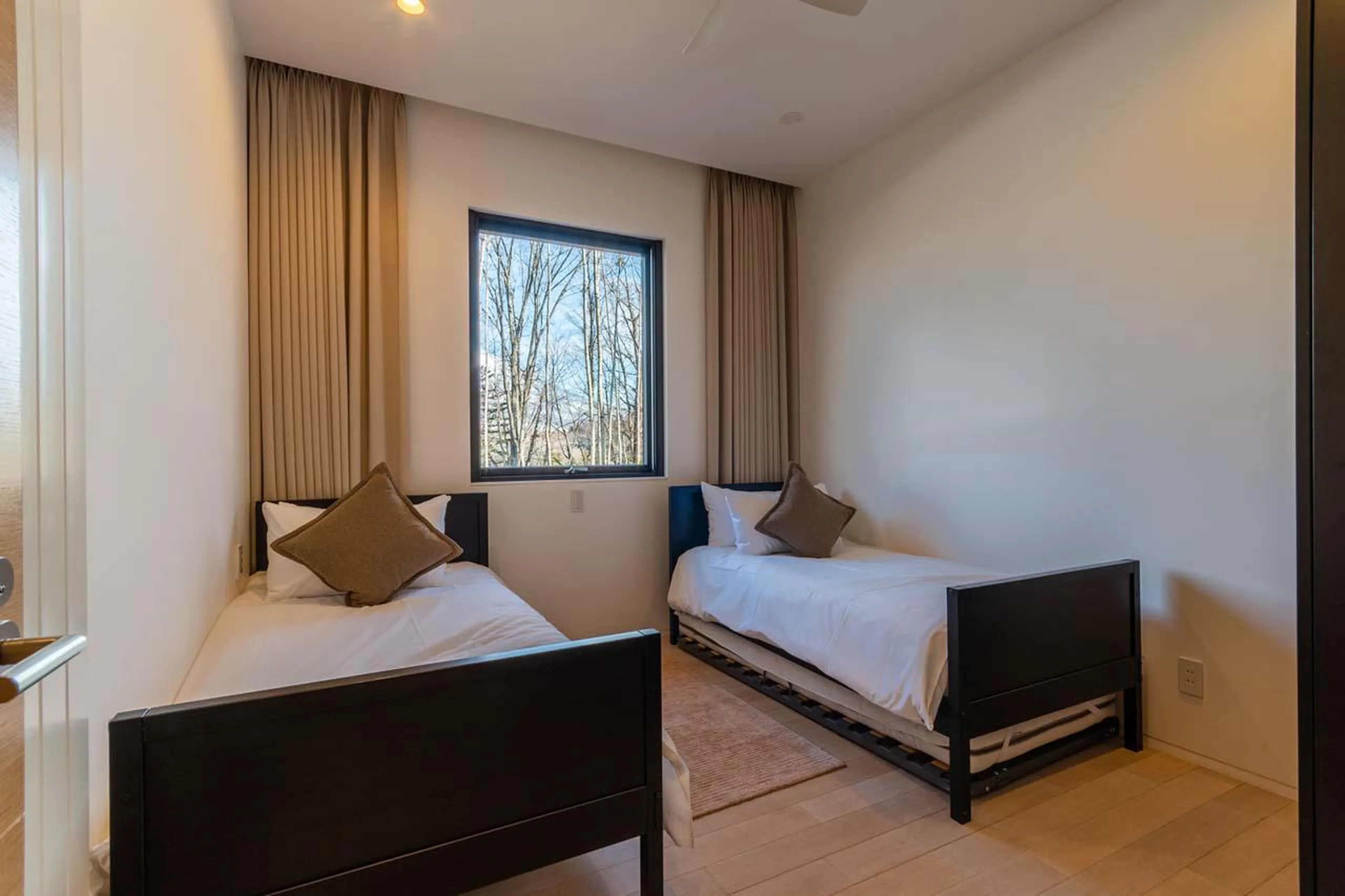 Twin bedroom with trundle roll-out beds at Yanagi House in Niseko